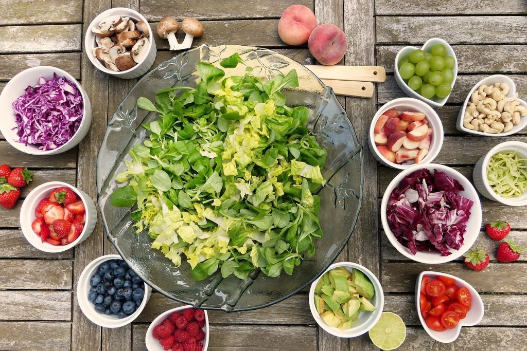 saladier avec salade entouré de petits bols avec ingrédients pour salade composée