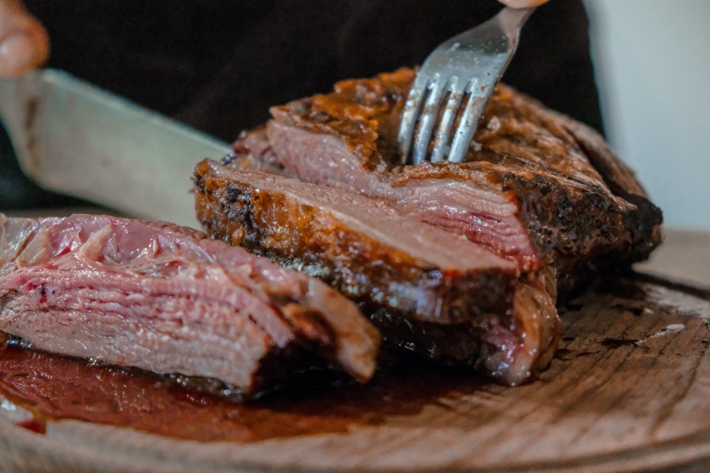 zoom sur morceau de viande découpée par une personne