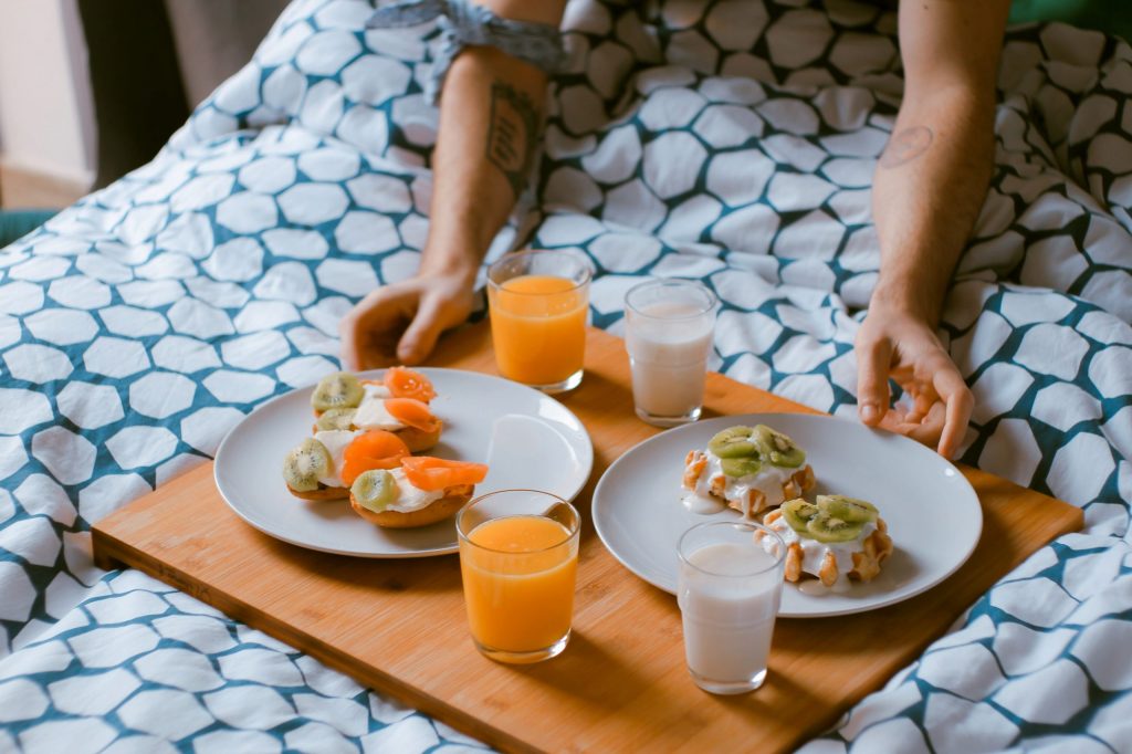 Plateau pour le petit-déjeuner posé sur la couette d'un lit