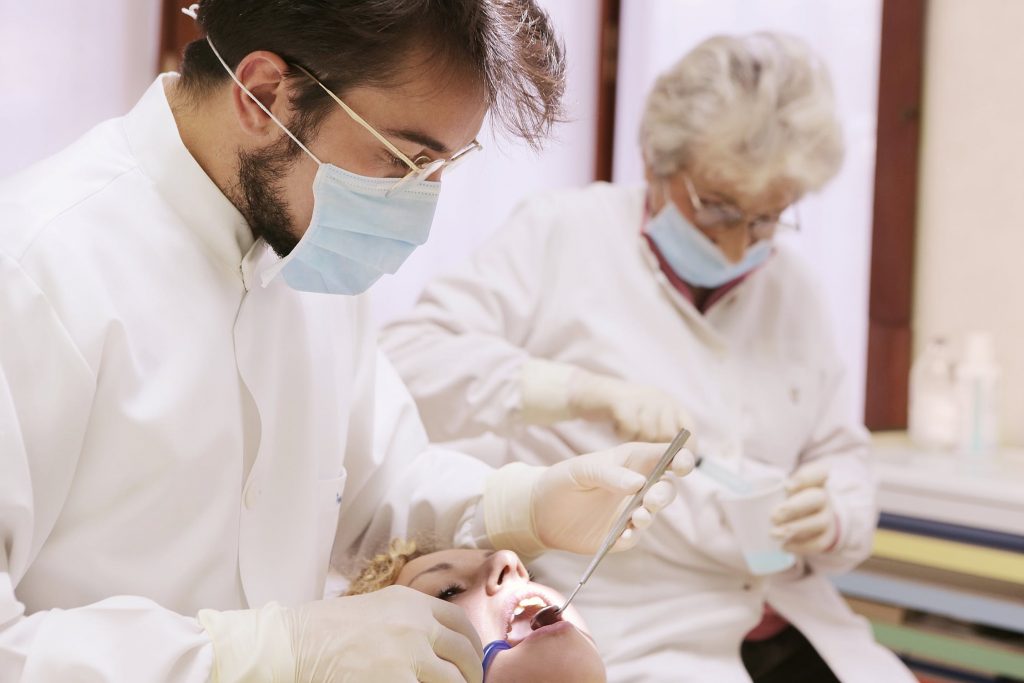 Dentiste qui examine les dents d'une patiente